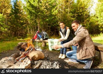 camping, travel, tourism, hike and people concept - happy family roasting marshmallow over campfire. happy family roasting marshmallow over campfire. happy family roasting marshmallow over campfire