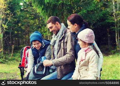 camping, travel, tourism, hike and people concept - happy family with backpacks and thermos at camp. happy family with backpacks and thermos at camp. happy family with backpacks and thermos at camp