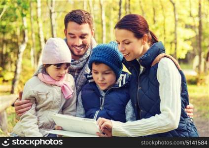 camping, travel, tourism, hike and people concept - happy family with tablet pc computer at camp in woods. happy family with tablet pc at camp