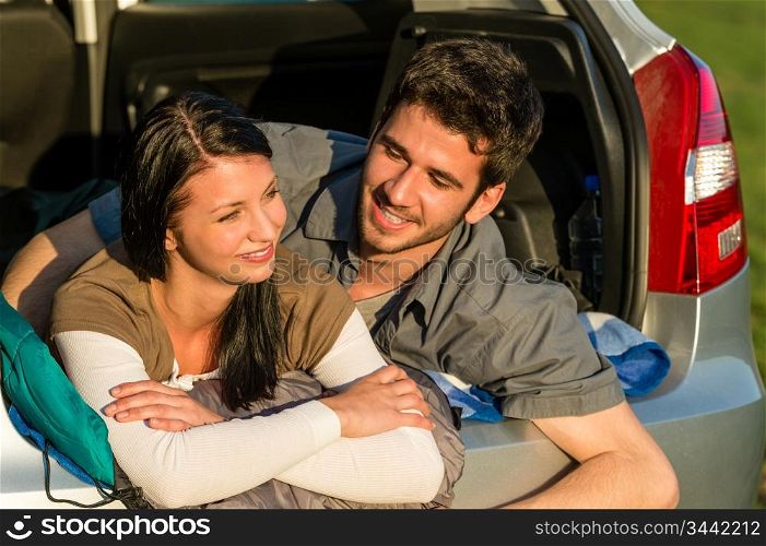 Camping young couple hugging together in car summer sunset