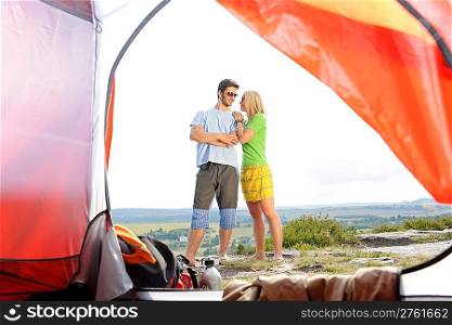 Camping young couple outside tent panoramic countryside view