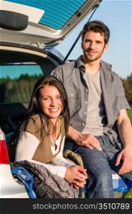 Camping young couple smiling together in car summer sunset