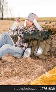 Camping young woman hiking with backpack sitting in countryside