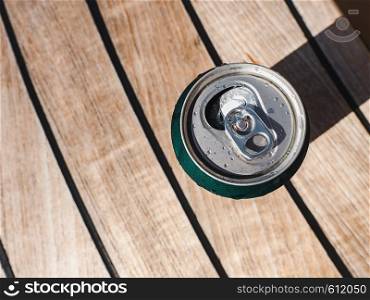 Can of beer on the background of a beautiful, wooden surface. Top view, close-up. Concept of leisure and travel. Can of beer on a beautiful background