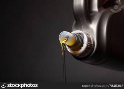 Can with car engine oil pouring in front black background