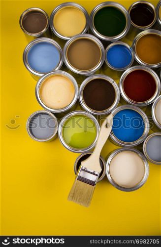 Can with paint and paintbrush, yellow background