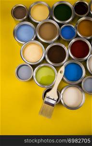 Can with paint and paintbrush, yellow background