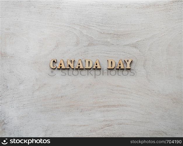 CANADA DAY. Wooden, unpainted letters on a white table. Close-up, top view. Beautiful photo with a space for your inscriptions. Congratulations to loved ones, relatives, family, friends and colleagues. CANADA DAY. Wooden letters on a white table