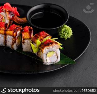 Canada roll with snow crab on black plate
