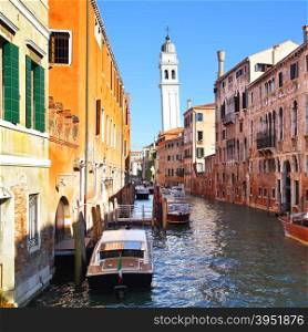 Canal and famous leaning bell tower in Venice, Italy