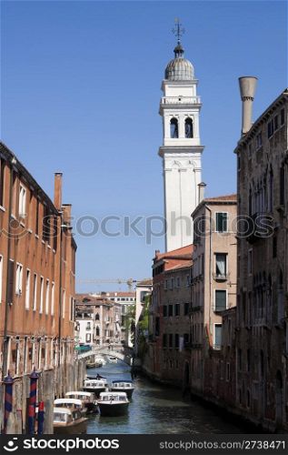 Canal and tower over blue sky in Venice, Italy