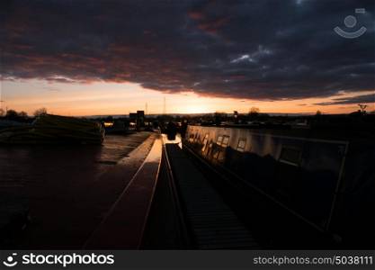 Canal boats in marina during dark cloudy sunset