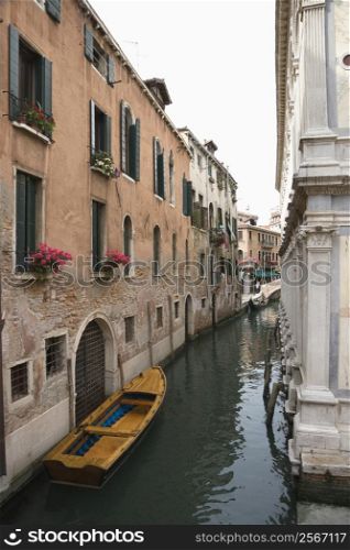 Canal with boat and buildings in Venice, Italy.