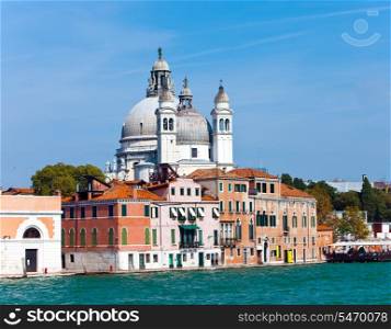 Canal with boats and Basilica Santa Maria della Salute, Venice, Italy