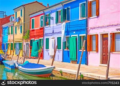 Canal with boats and colorful houses in Burano Island, Venice, Italy
