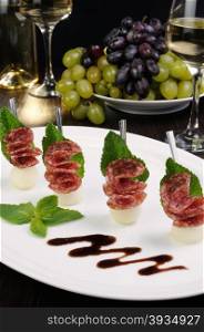 Canape of balls a melon and salami with mint