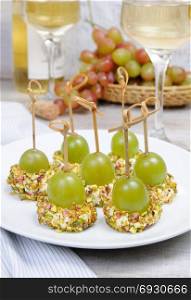 Canape of cottage cheese cushions in pistachios with grapes