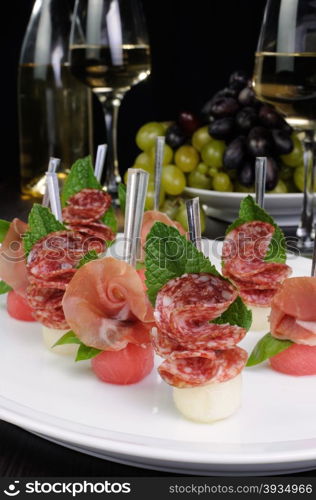 Canape of watermelon balls with a melon with gammon and salami