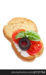 Canape with cream cheese, Tomato, Olive with basil on a toasted cracker