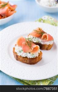 Canape with smoked salmon and cream cheese on plate, selective focus