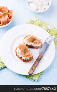 Canape with smoked salmon and cream cheese on plate, selective focus