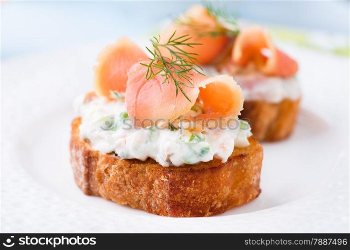 Canape with smoked salmon and cream cheese on plate, selective focus, low angle view