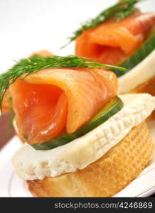 Canapes with smoked salmon,cheese and cucumber. close up