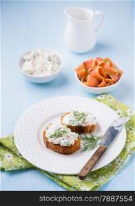 Canapes with soft cheese spread on white plate, selective focus