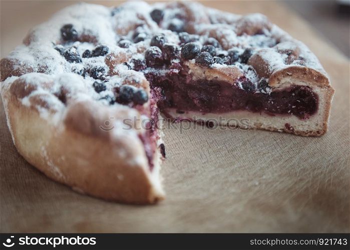 Canberry cake with blackberry on a wooden table