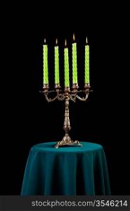 candelabrum with burning candles on the table isolated on black background