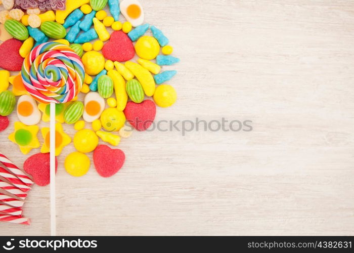 Candies with different shapes and colors on a gray wooden background