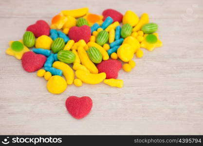 Candies with different shapes and colors on a gray wooden background