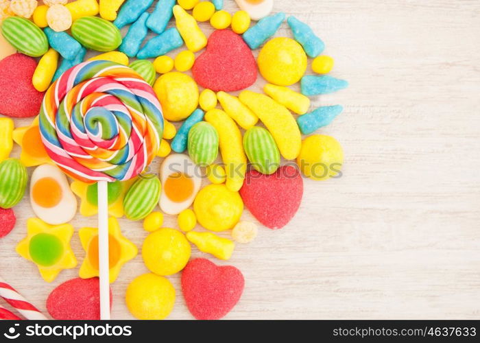 Candies with different shapes and colors on a gray wooden background