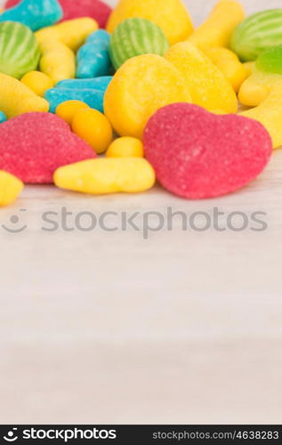 Candies with different shapes and colors on a gray wooden background