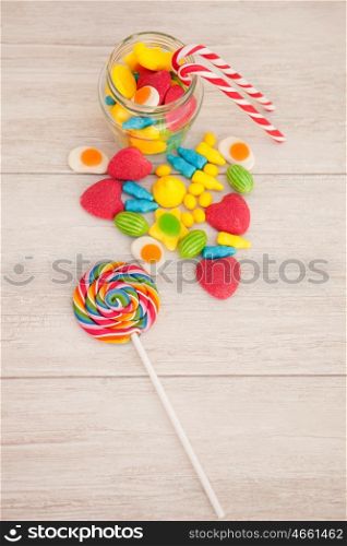 Candies with different shapes and colors on a gray wooden background