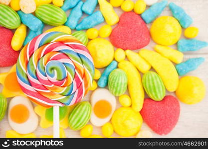 Candies with different shapes and colors on a gray wooden background