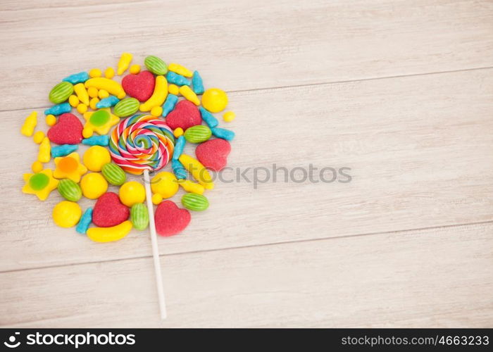 Candies with different shapes and colors on a gray wooden background