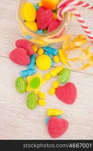 Candies with different shapes and colors on a gray wooden background