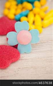 Candies with different shapes and colors on a gray wooden background. Soft focus