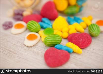 Candies with different shapes and colors on a gray wooden background. Soft focus
