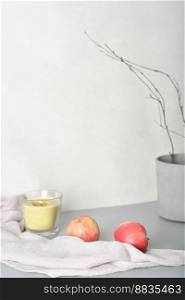 candle and apples on grey table with soft textile napkin and cement pot. ambient blog content. fall mood. vertical, copy space. candle and apples on grey table with soft textile napkin and cement pot. ambient blog content. fall mood. vertical, copy space. 