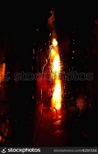 Candle burning in a wet glass closeup