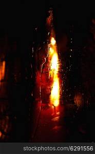 Candle burning in a wet glass closeup