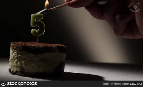 Candle five in tiramisu cake. Birthday vintage background.