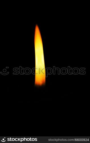 Candle flame in a darkened room. The flame providing the only light.