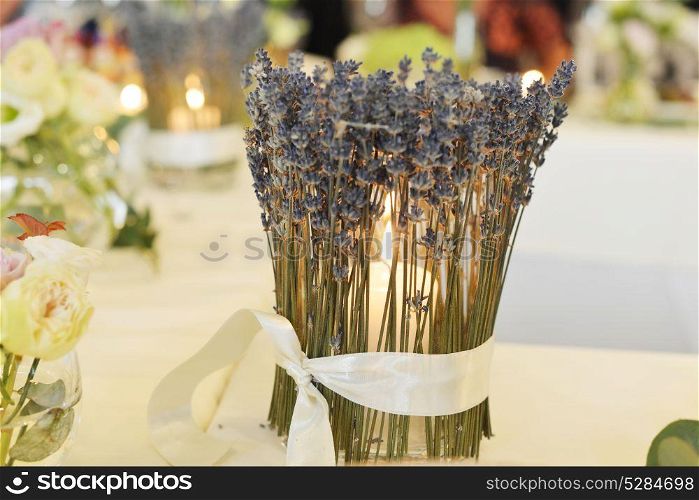 candle-holder, decorated with lavender, burns on table