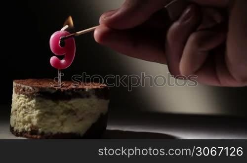 Candle nine in tiramisu cake. Birthday vintage background.