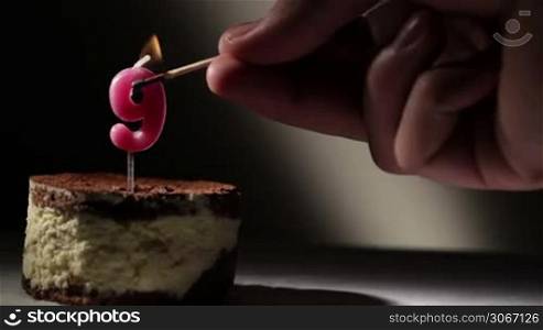 Candle nine in tiramisu cake. Birthday vintage background.