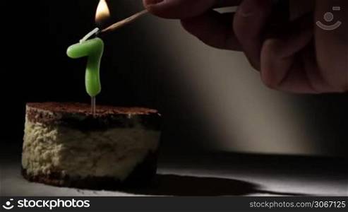 Candle seven in tiramisu cake. Birthday vintage background.