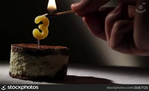 Candle three in tiramisu cake. Birthday vintage background.